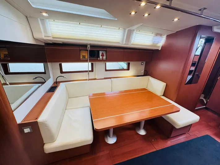 Flight Risk Yacht Photos Pics Luxurious interior of 2020 Beneteau Oceanis 51.1 yacht with elegant dining area and plush seating.