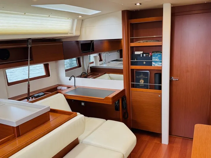 Flight Risk Yacht Photos Pics Interior of 2020 Beneteau Oceanis 51.1 yacht with modern wood finish and seating area.
