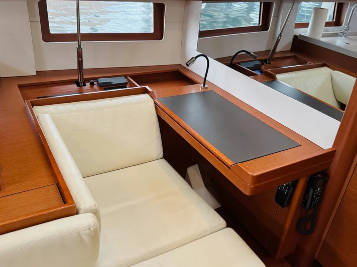 Flight Risk Yacht Photos Pics Luxurious interior of 2020 Beneteau Oceanis 51.1 yacht with elegant seating and workspace.