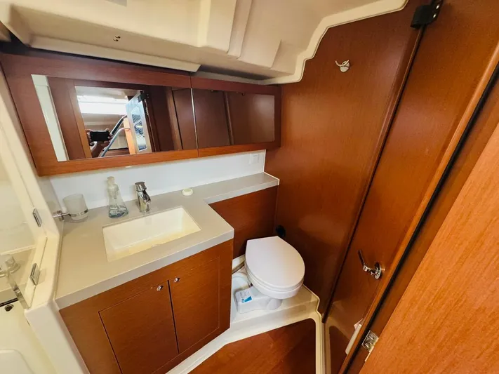 Flight Risk Yacht Photos Pics 2020 Beneteau Oceanis 51.1 yacht bathroom with wooden cabinetry and modern fixtures.