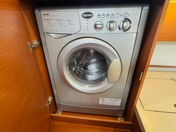 Flight Risk Yacht Photos Pics Washing machine inside Beneteau Oceanis 51.1 yacht, 2020 model, in a wooden cabinet.