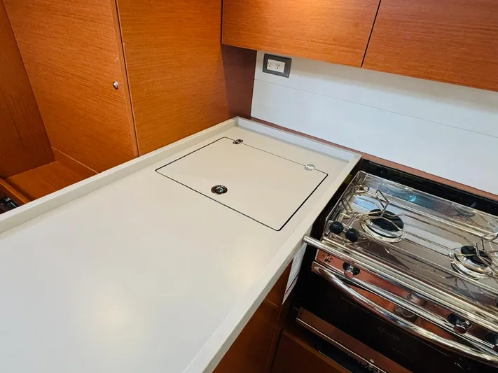 Flight Risk Yacht Photos Pics Modern galley kitchen in 2020 Beneteau Oceanis 51.1 yacht with stove and sleek cabinetry.