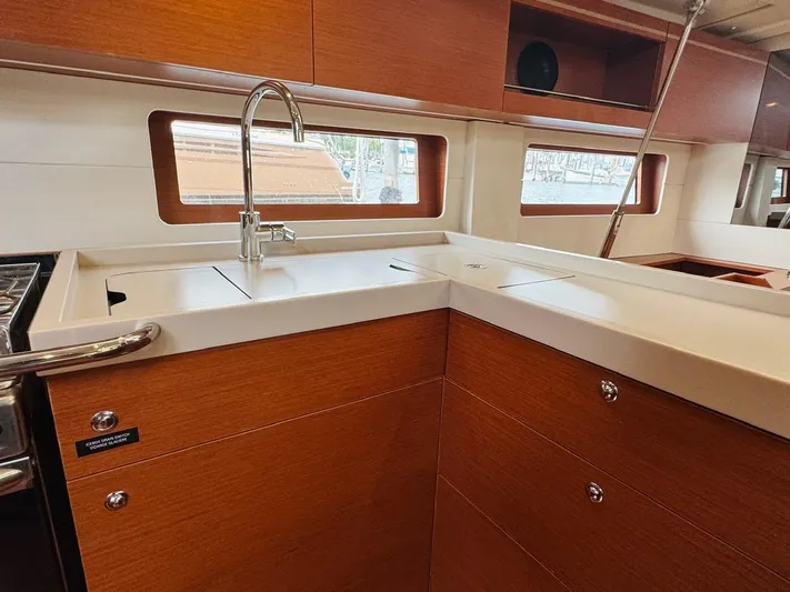 Flight Risk Yacht Photos Pics Modern kitchen interior of 2020 Beneteau Oceanis 51.1 yacht with sleek wood cabinetry.