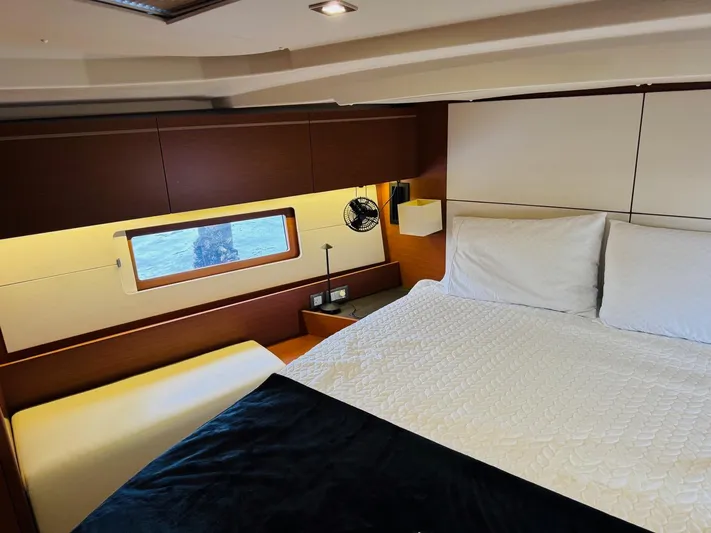 Flight Risk Yacht Photos Pics Luxurious cabin interior of 2020 Beneteau Oceanis 51.1 yacht with cozy bedding and window view.