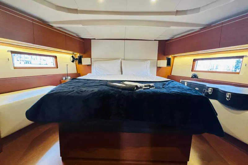 Flight Risk Yacht Photos Pics Luxurious cabin interior of 2020 Beneteau Oceanis 51.1 yacht with elegant bedding and wood accents.