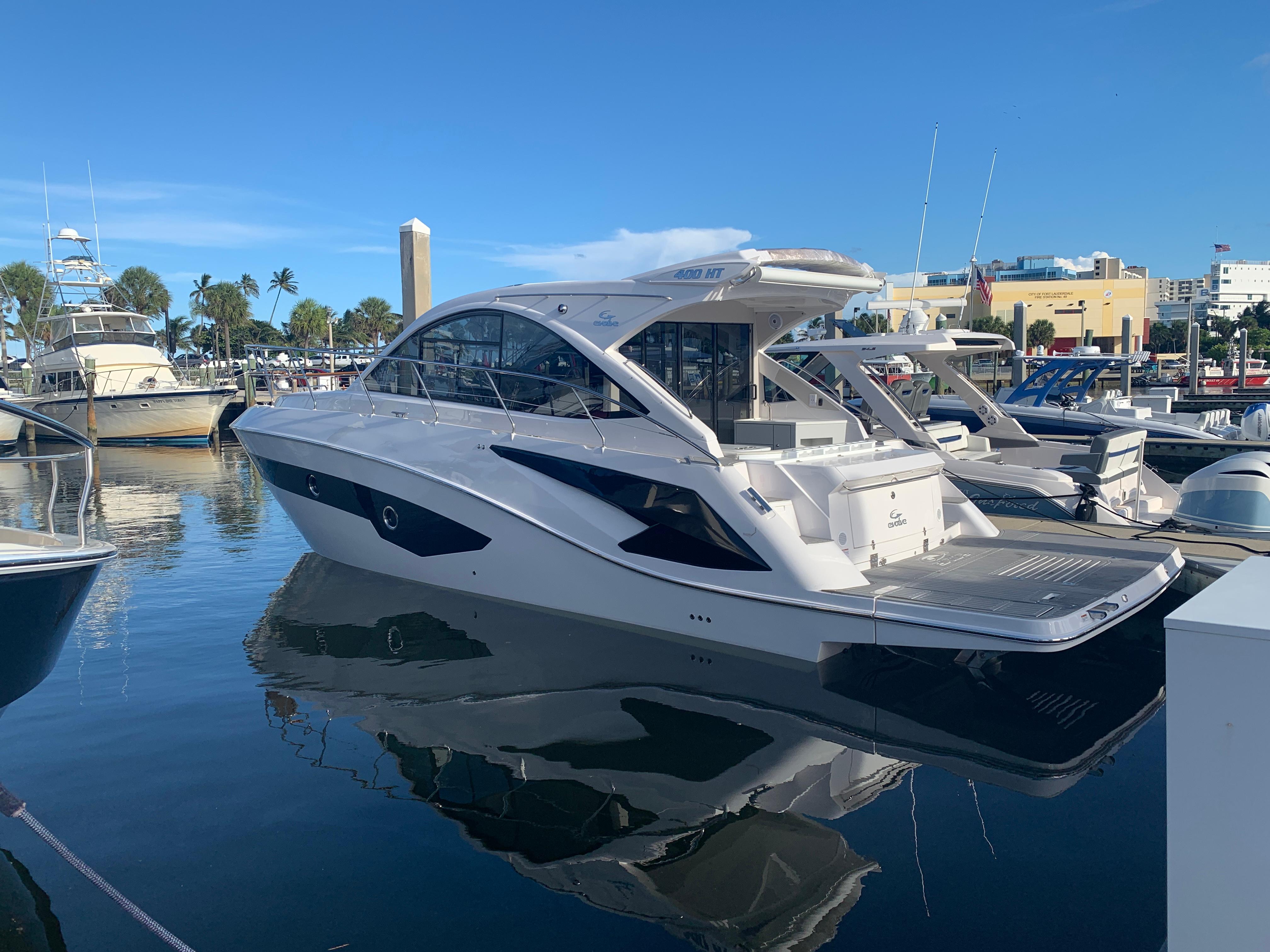 Evolve 400HT 2021 yacht docked in marina, reflecting on calm water.