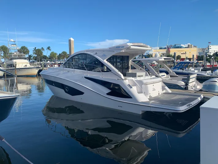 Romaniac Yacht Photos Pics Evolve 400HT 2021 yacht docked in marina, reflecting on calm water.
