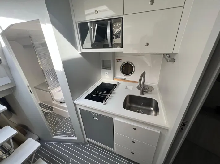 Romaniac Yacht Photos Pics Compact kitchen area in a 2021 Evolve 400HT boat, featuring modern appliances and sleek design.