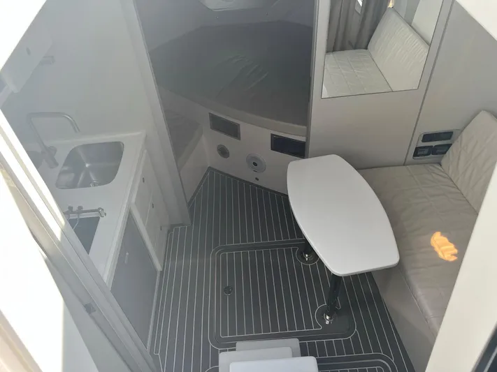 Romaniac Yacht Photos Pics Interior of 2021 Evolve 400HT boat with kitchenette and seating area.
