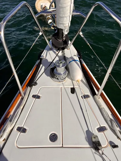 Airwaves Yacht Photos Pics Bow of 2006 J Boats J/124 sailboat with winch and railing, on calm water.