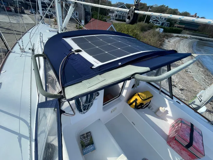 Airwaves Yacht Photos Pics 2006 J Boats J/124 sailboat with solar panel on deck, docked near shoreline.