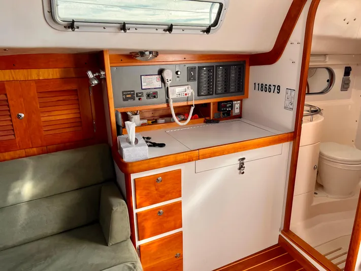 Airwaves Yacht Photos Pics 2006 J Boats J/124 interior with control panel, wooden cabinetry, and seating area.