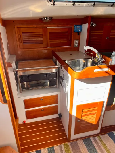 Airwaves Yacht Photos Pics 2006 J Boats J/124 yacht interior with wooden cabinetry and compact kitchen area.