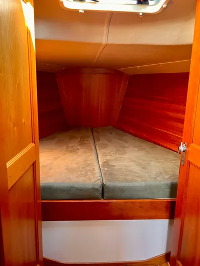 Airwaves Yacht Photos Pics 2006 J Boats J/124 cabin interior with wooden finish and cozy bedding.