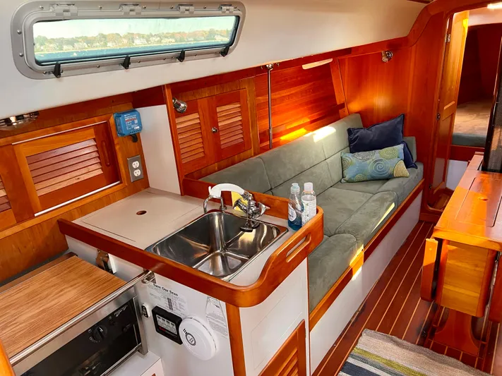 Airwaves Yacht Photos Pics Interior of 2006 J Boats J/124 sailboat with cozy seating and compact kitchen area.