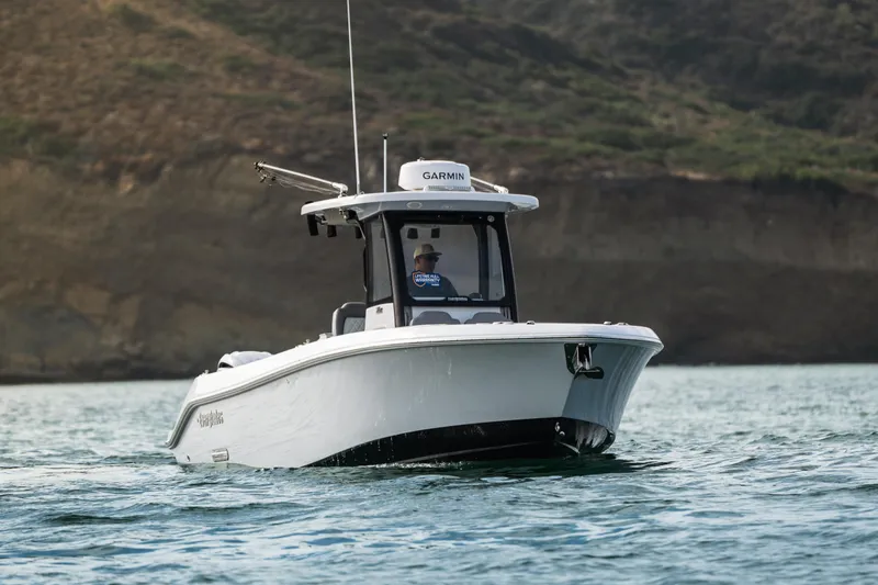 Shark Bait Yacht Photos Pics 2025 Everglades 285 Center Console boat cruising on water near rocky shoreline.