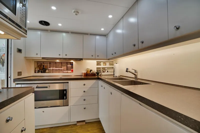 Diamond Yacht Photos Pics Modern kitchen with white cabinets, stainless steel appliances, and under-cabinet lighting in an AB 116 model yacht, 2012.