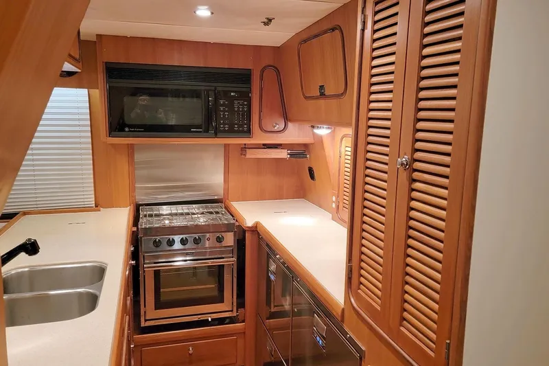 Carolina Yacht Photos Pics 2001 Nordhavn 46 yacht kitchen with wood cabinetry, stove, microwave, and double sink.