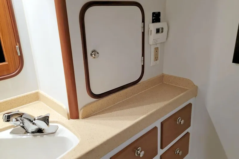 Carolina Yacht Photos Pics 2001 Nordhavn 46 yacht bathroom with sink, storage cabinets, and control panel.