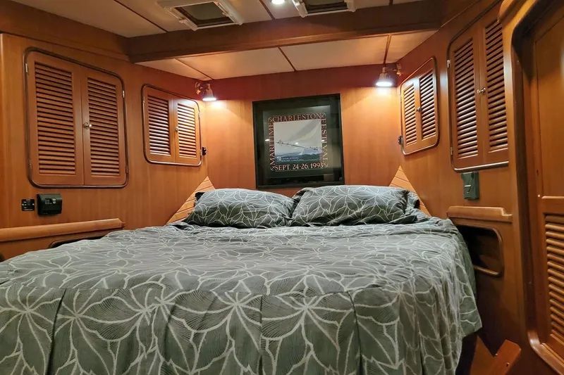 Carolina Yacht Photos Pics Cozy cabin interior of 2001 Nordhavn 46 yacht with wood paneling and double bed.