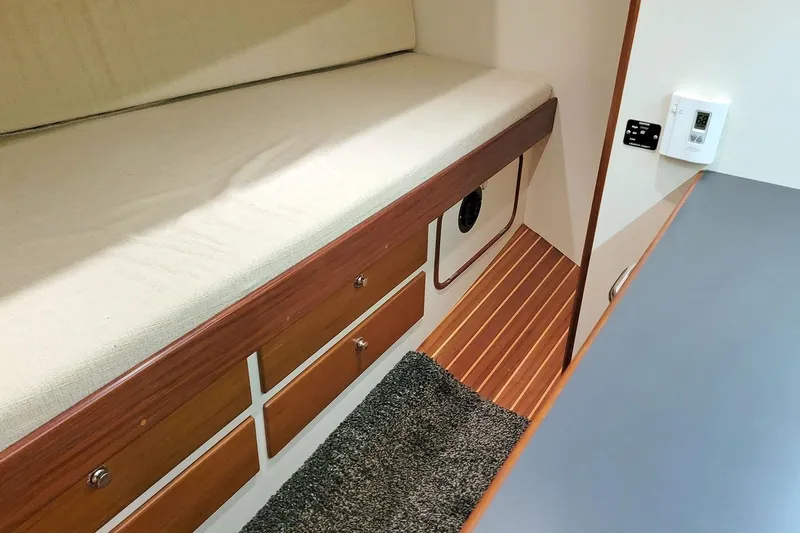Carolina Yacht Photos Pics 2001 Nordhavn 46 interior with wooden drawers, cushioned bench, and carpeted floor.