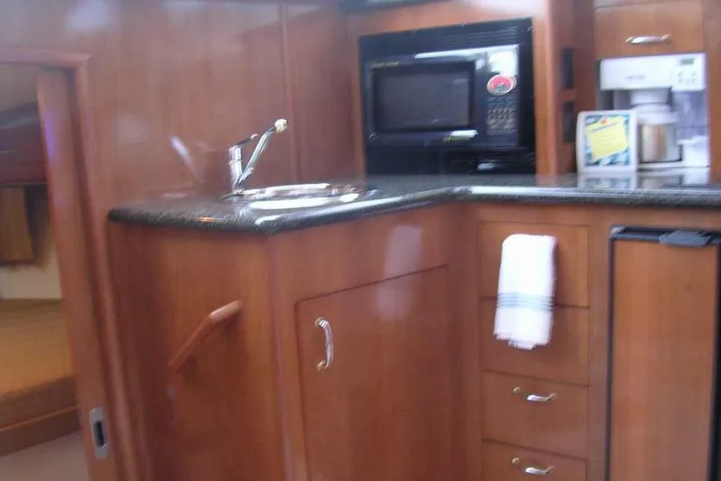  Yacht Photos Pics 2006 Carver 41 Cockpit Motor Yacht interior with kitchenette, featuring wood cabinetry and modern appliances.