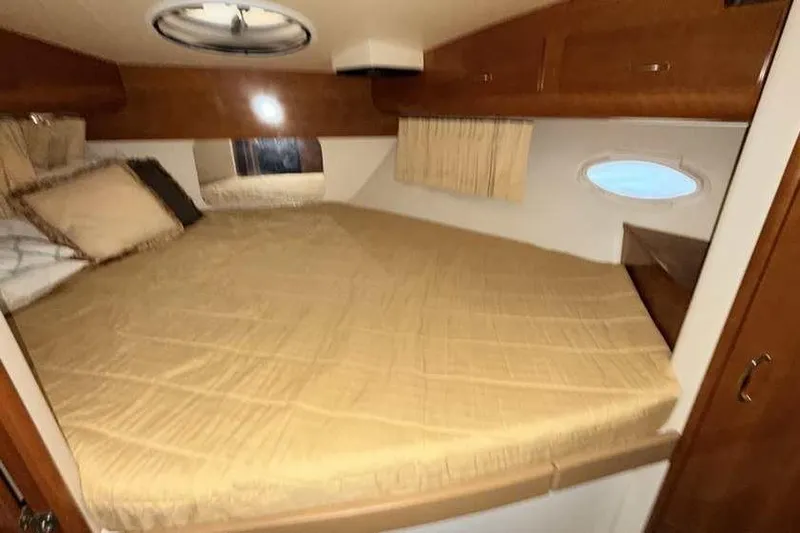  Yacht Photos Pics Interior cabin of 2006 Carver 41 Cockpit Motor Yacht with cozy bed and wooden accents.