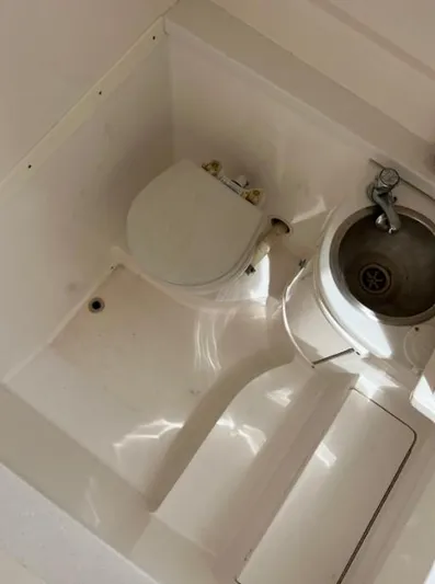 Blu Yacht Photos Pics Compact bathroom in a 2015 Intrepid 327 boat, featuring a toilet and sink.