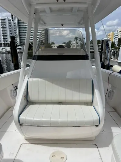 Blu Yacht Photos Pics 2015 Intrepid 327 boat interior with white seating, docked near waterfront buildings.