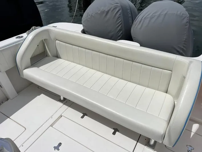 Blu Yacht Photos Pics White leather seating on a 2015 Intrepid 327 boat, with covered engines in the background.