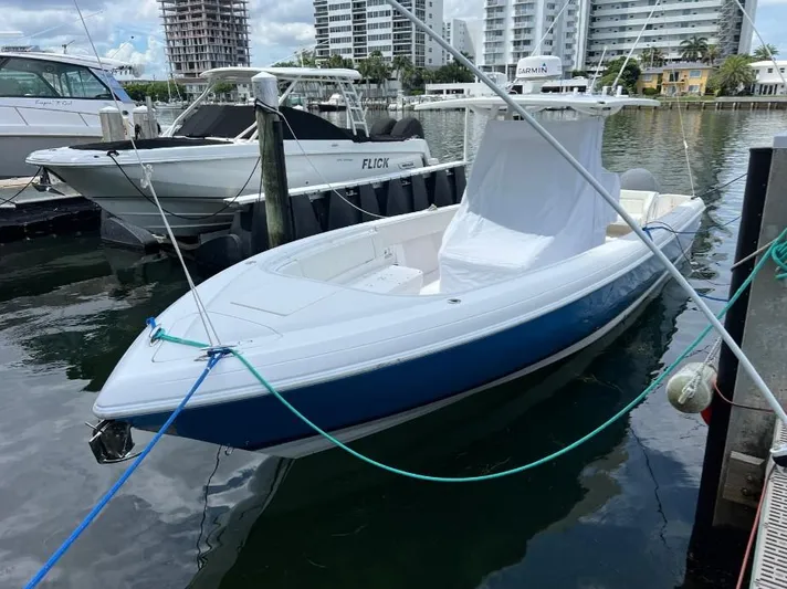 Blu Yacht Photos Pics 2015 Intrepid 327 boat docked in marina, surrounded by other vessels and cityscape.