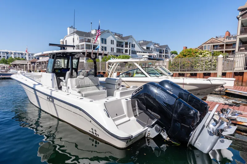  Yacht Photos Pics 2024 HCB 39 Speciale boat docked at a marina with waterfront buildings in the background.
