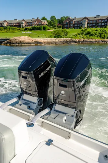  Yacht Photos Pics 2024 HCB 39 Speciale with twin Mercury outboard engines cruising near waterfront homes.