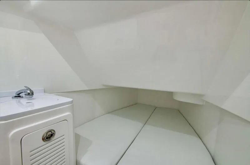  Yacht Photos Pics 2024 HCB 39 Speciale cabin interior with white cushioned seating and compact sink.