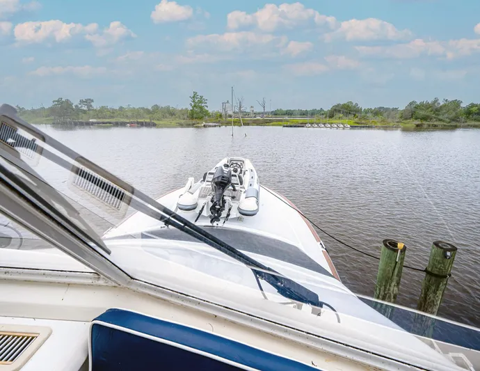 Double Down Yacht Photos Pics 1997 Ocean Yachts 60 Super Sport EB cruising on a serene river under a blue sky.