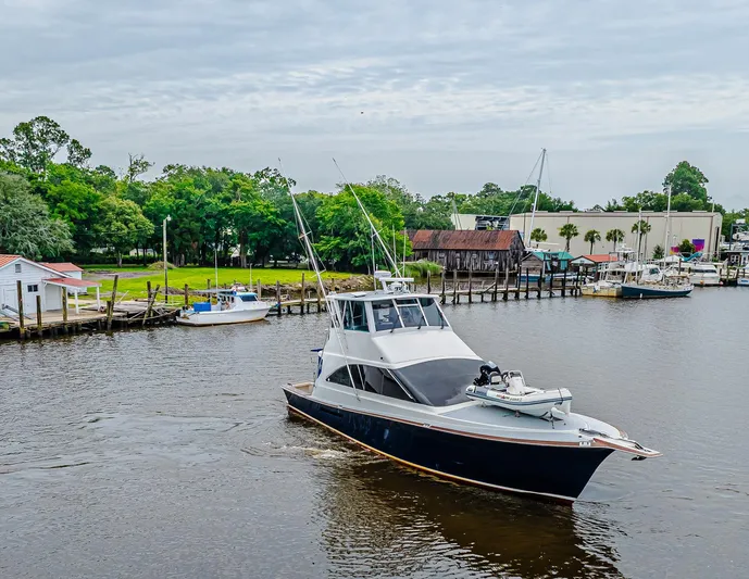 Double Down Yacht Photos Pics 1997 Ocean Yachts 60 Super Sport EB cruising near a marina with lush greenery.
