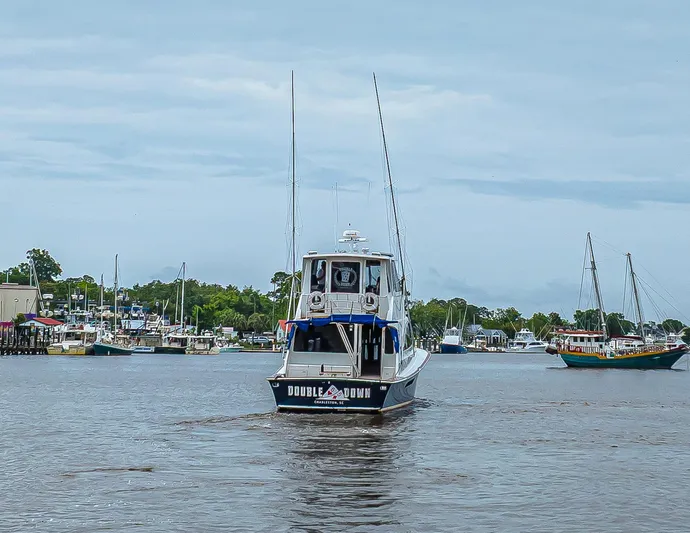 Double Down Yacht Photos Pics 1997 Ocean Yachts 60 Super Sport EB cruising in a marina with sailboats in the background.