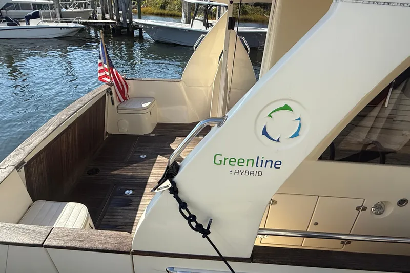 Landfall Yacht Photos Pics 2013 Greenline 33 Hybrid yacht with American flag, docked by the water.