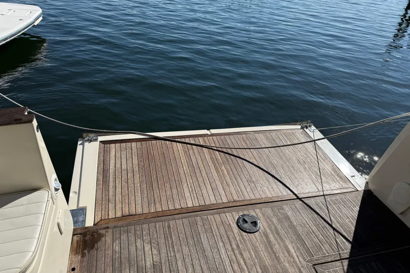 Landfall Yacht Photos Pics 2013 Greenline 33 boat deck with wooden finish, docked on calm water.