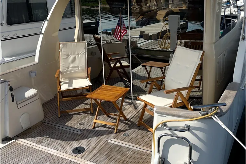 Landfall Yacht Photos Pics Deck of 2013 Greenline 33 yacht with chairs and table, docked at marina.