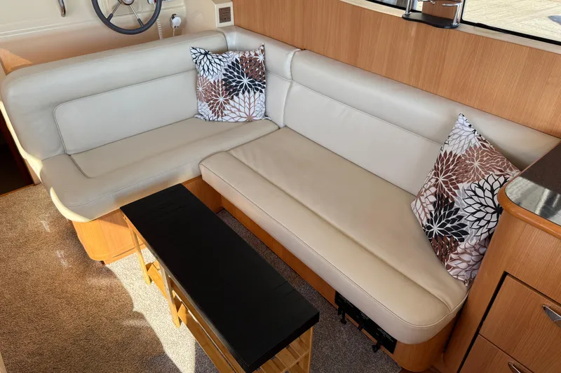 Landfall Yacht Photos Pics Interior of 2013 Greenline 33 yacht with beige leather seating and decorative pillows.