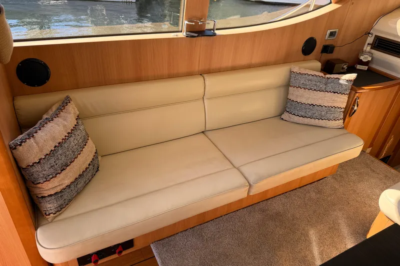 Landfall Yacht Photos Pics Luxurious interior of 2013 Greenline 33 yacht with beige sofa and decorative pillows.