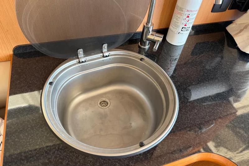 Landfall Yacht Photos Pics Stainless steel sink in 2013 Greenline 33 yacht kitchen with black countertop.