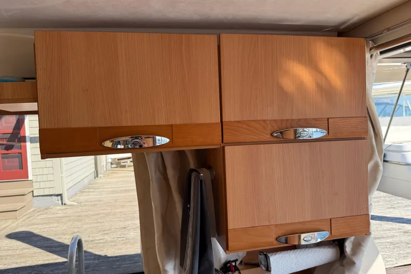 Landfall Yacht Photos Pics Wooden cabinets inside a 2013 Greenline 33 boat, featuring sleek chrome handles.