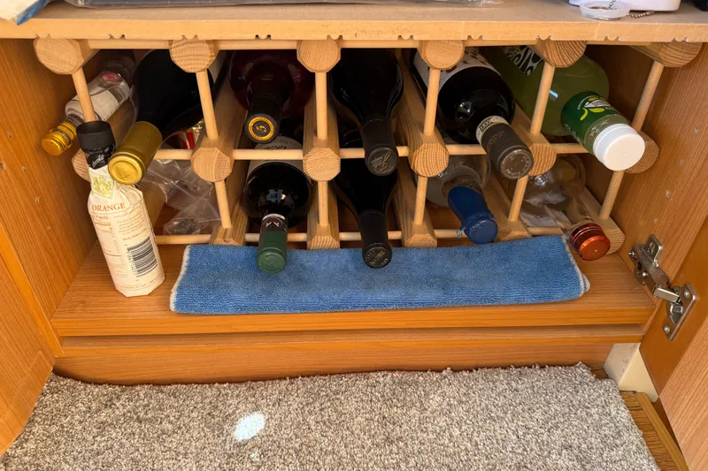 Landfall Yacht Photos Pics Wine rack in a 2013 Greenline 33 boat, stocked with various bottles.