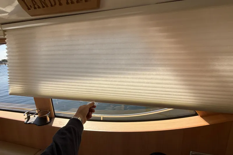 Landfall Yacht Photos Pics Person adjusting window blind on 2013 Greenline 33 yacht interior.