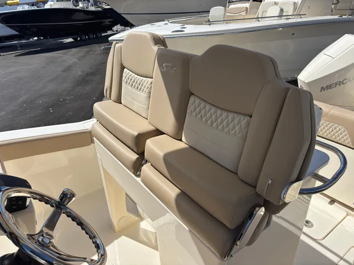 Yacht Photos Pics 2025 Scout 260 LXF boat seats with beige upholstery and steering wheel.