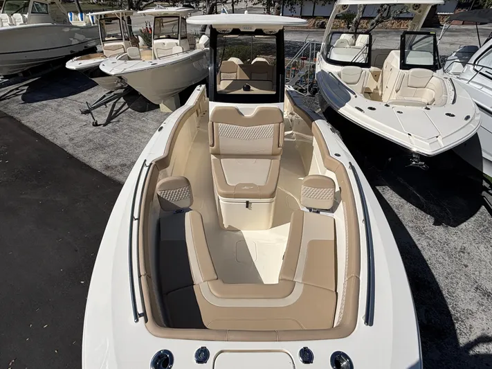  Yacht Photos Pics 2025 Scout 260 LXF boat with beige interior, displayed among other boats at a marina.