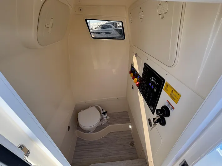  Yacht Photos Pics 2025 Scout 260 LXF boat interior with compact marine toilet and control panel.