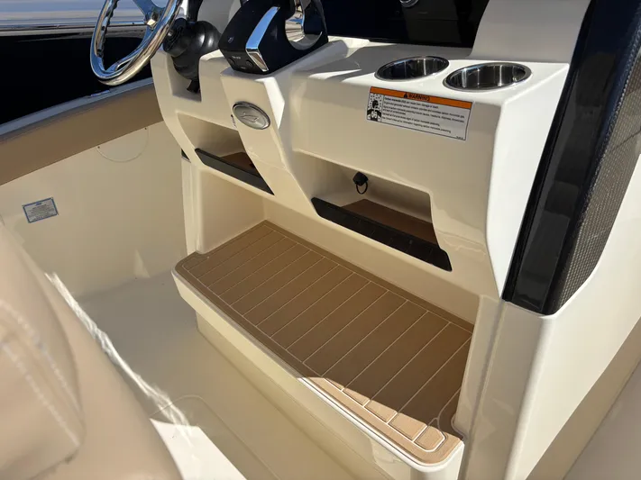  Yacht Photos Pics 2025 Scout 260 LXF boat console with cup holders and footrest.